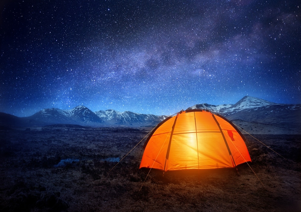 Camping Tent glowing under starry night sky