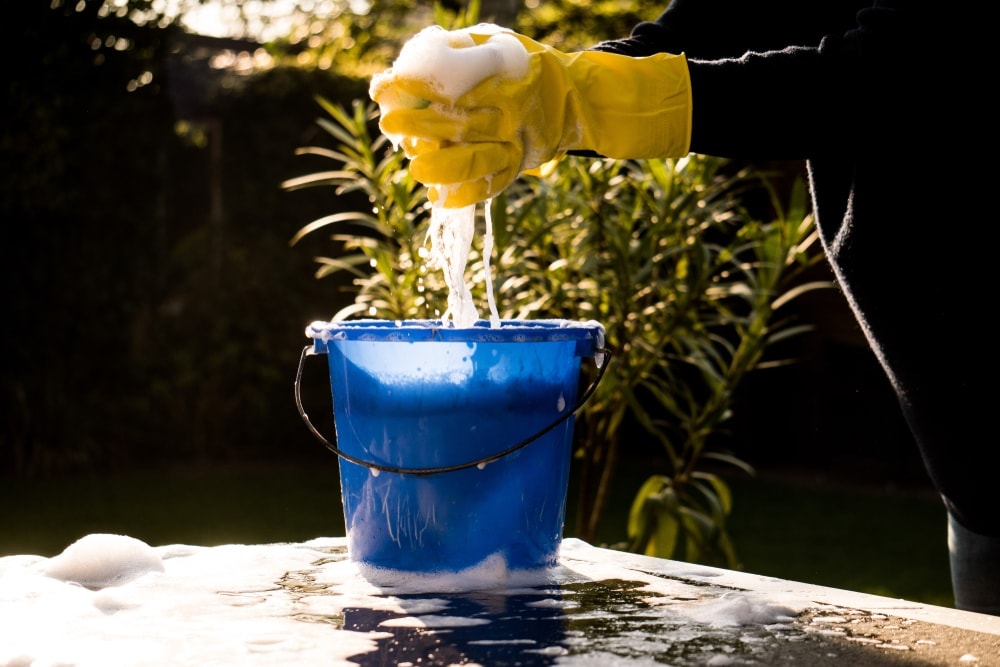 Person squeezing sponge on tub