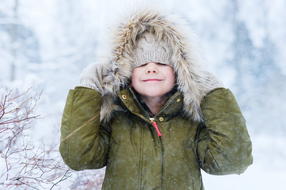 Adorable kid wearing a park in snowy day