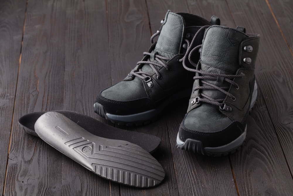 Camping boots and heated insoles on a floor