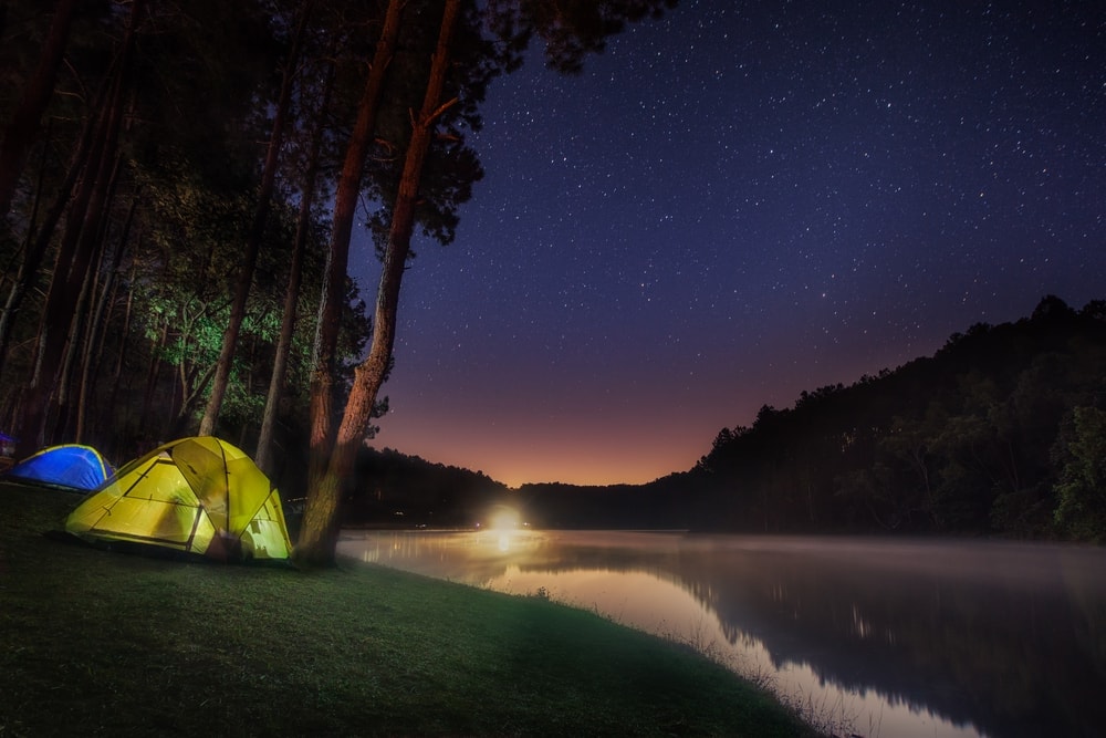 Camping tent beside lake in night time