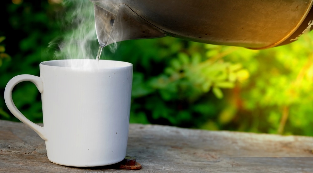 Pouring hot water to a mug from an electric kettle