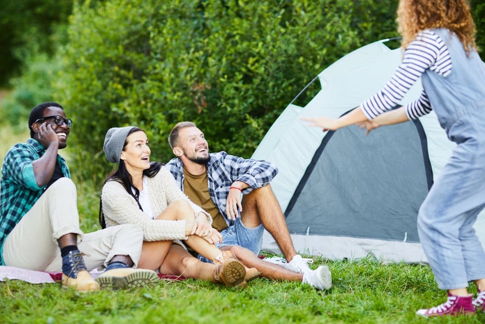 Friends playing camping games during the day