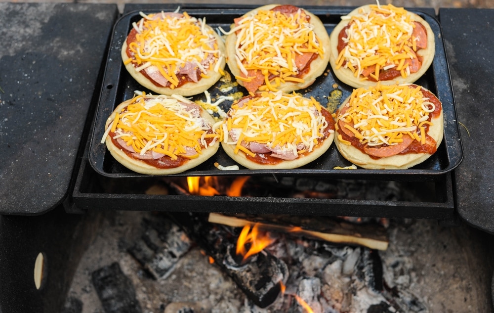 Pizzas on the pan over a campfire