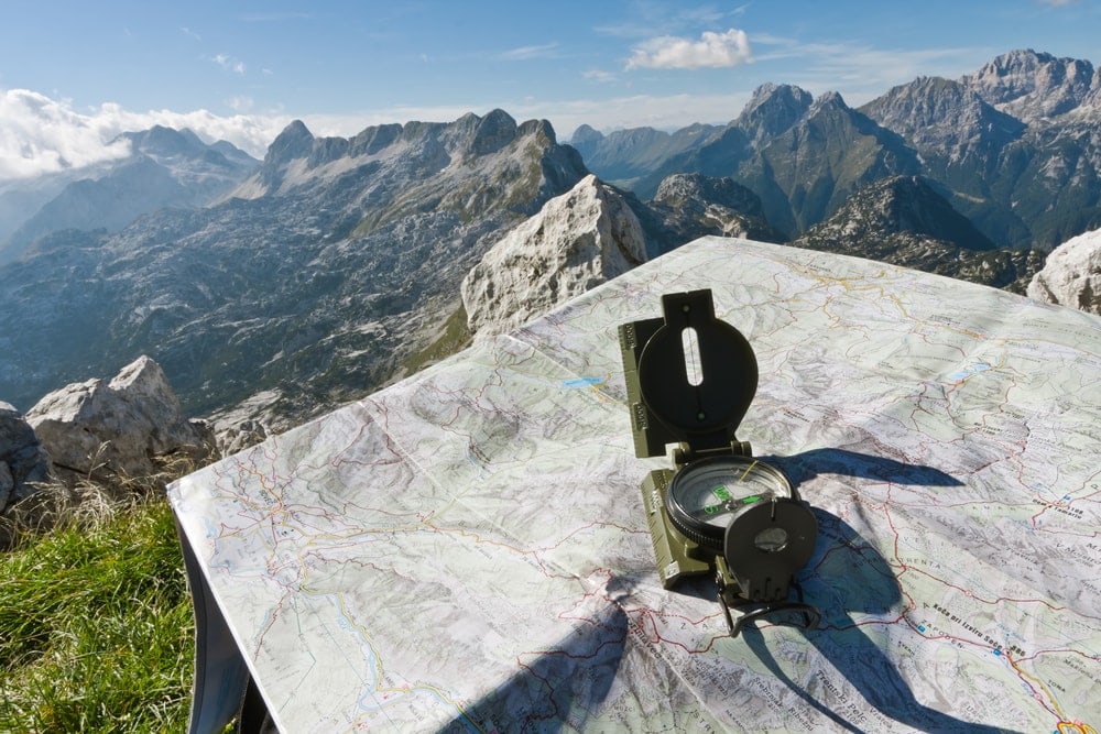 A compass and a map on the top of the mountain use for backcountry hiking