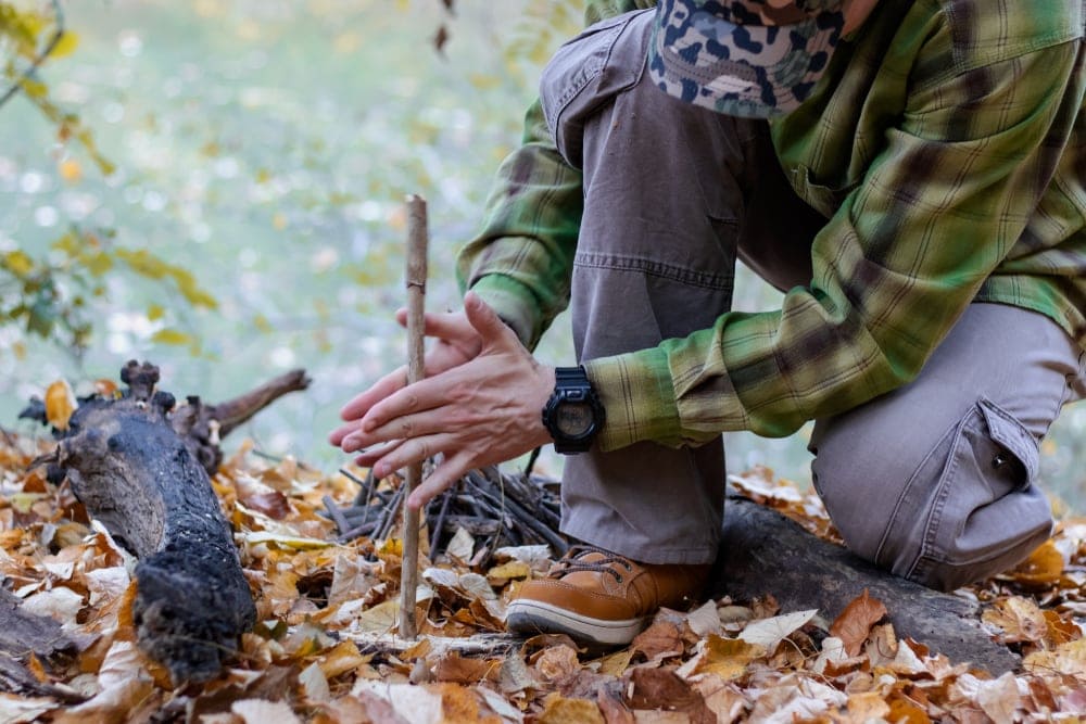 Man making a fire using a hand drill method