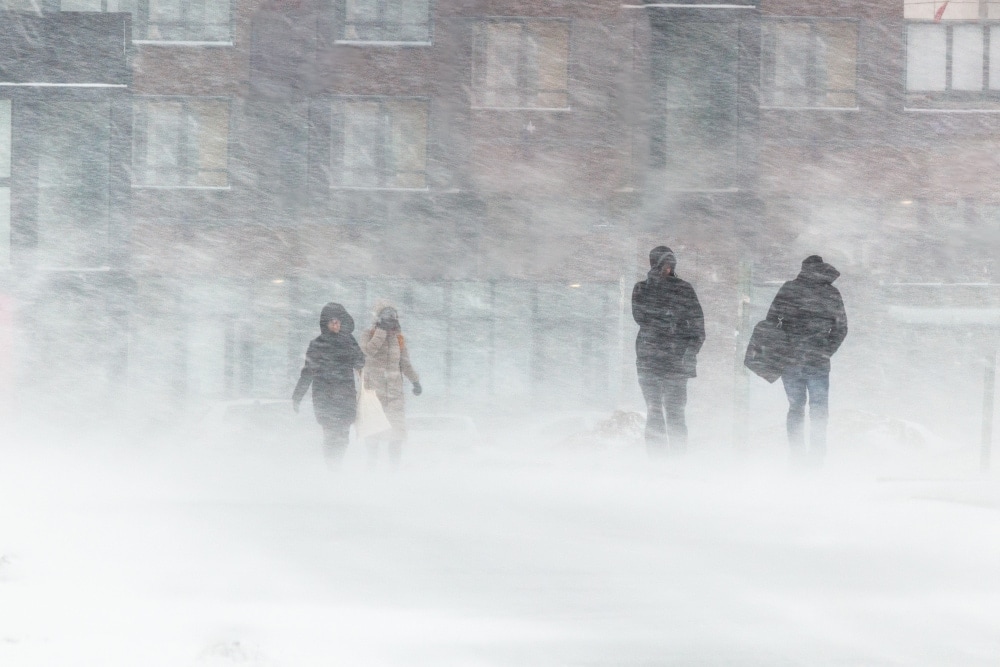 People against strong winds and blizzards background of houses