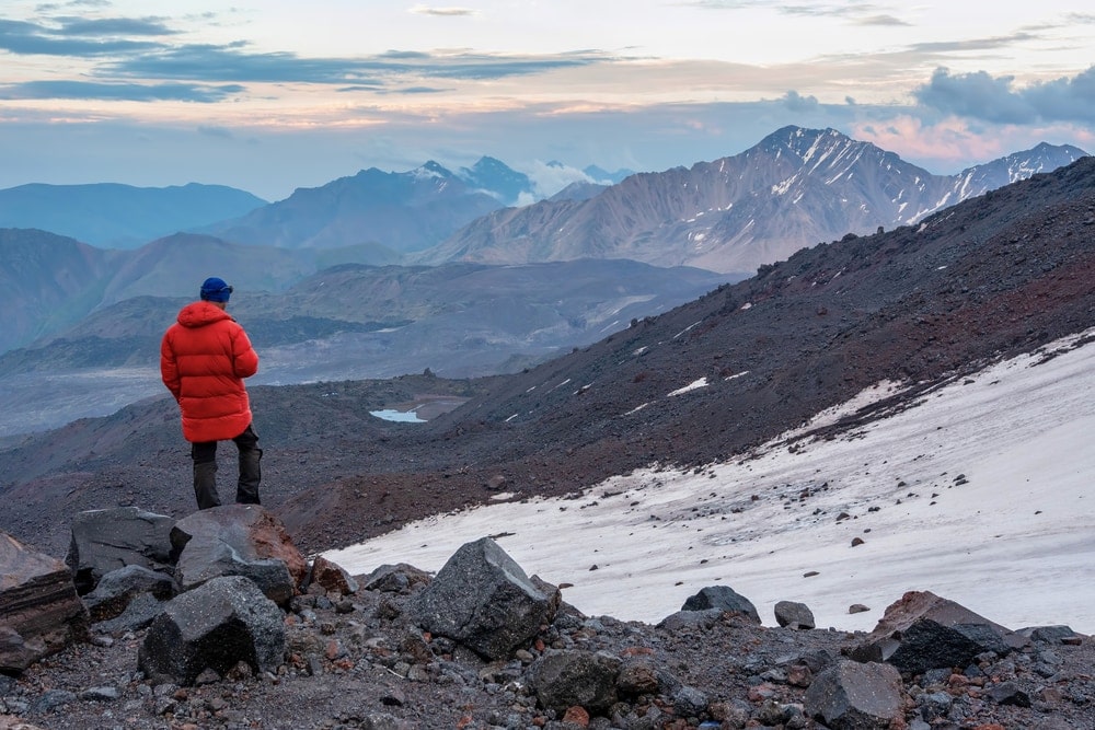 Hiker standing on top of the hill wearing a fjallraven winter parka