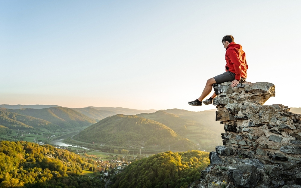 Hiker sitting on a cliff wearing a arcteryx jacket