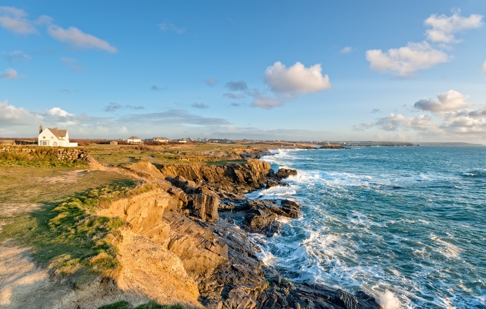Sunny cliff with big waves on rocks due to high tide