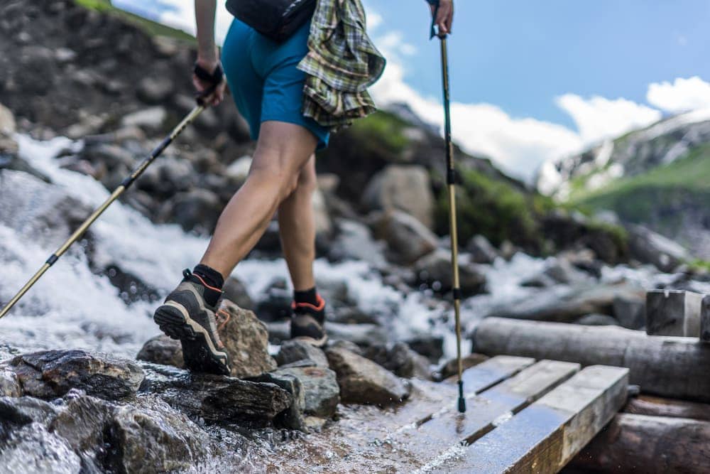 Man using trekking poles on rocks