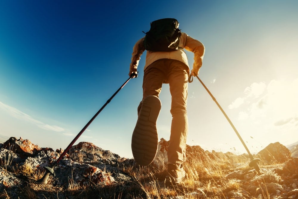 Man climbing up with hiking poles