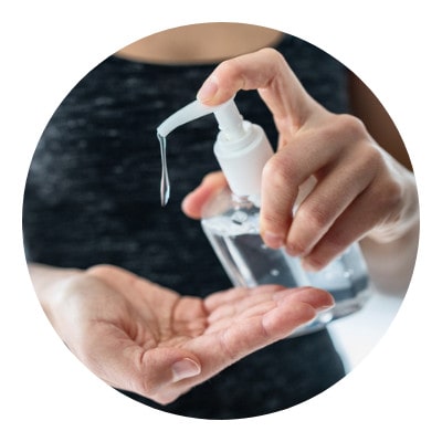 Woman sanitizing her hand with alcohol