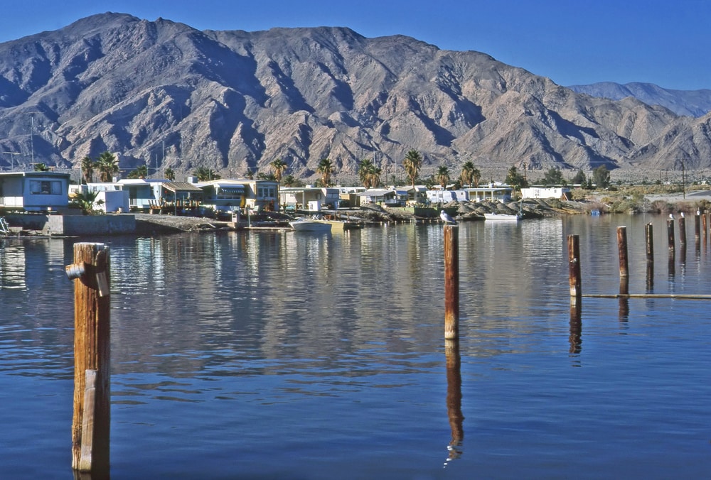 Salton Sea at California with mountains and home in the background