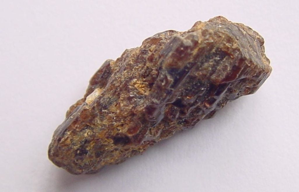 a painite specimen from Myanmar isolated on a white background