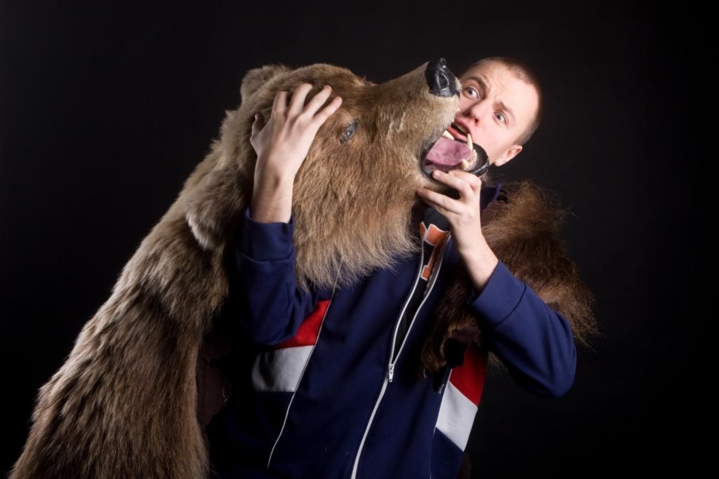 a bear hugging a scared human 