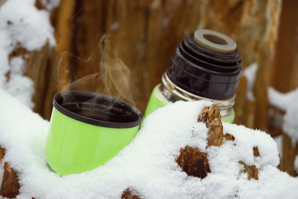 a hot tea in a flask int he snow