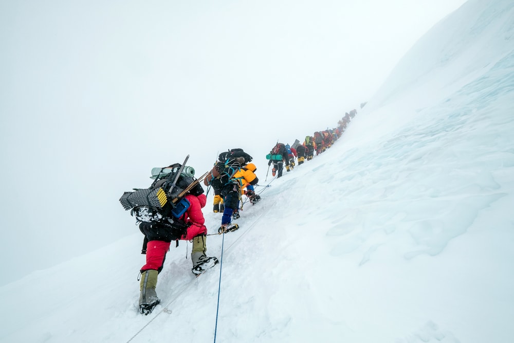 group of climbers holding on a fixed rope in the Himalaya Mountains