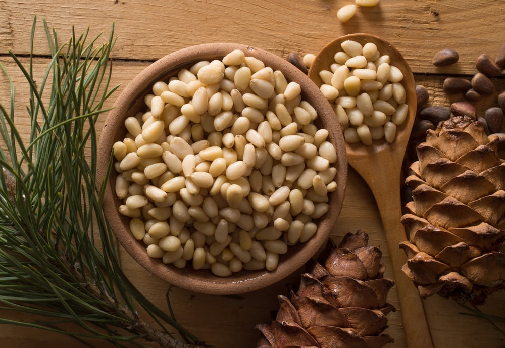 pine nuts and pine cones on a wooden table 