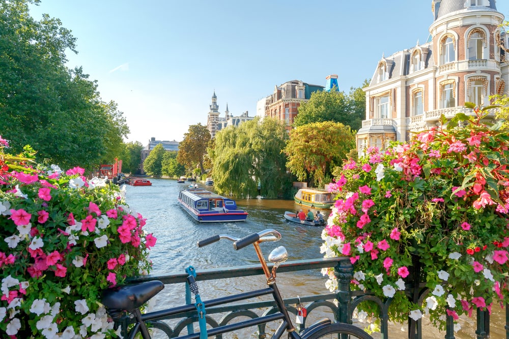 Canal on Amsterdam with flowers on the bridge