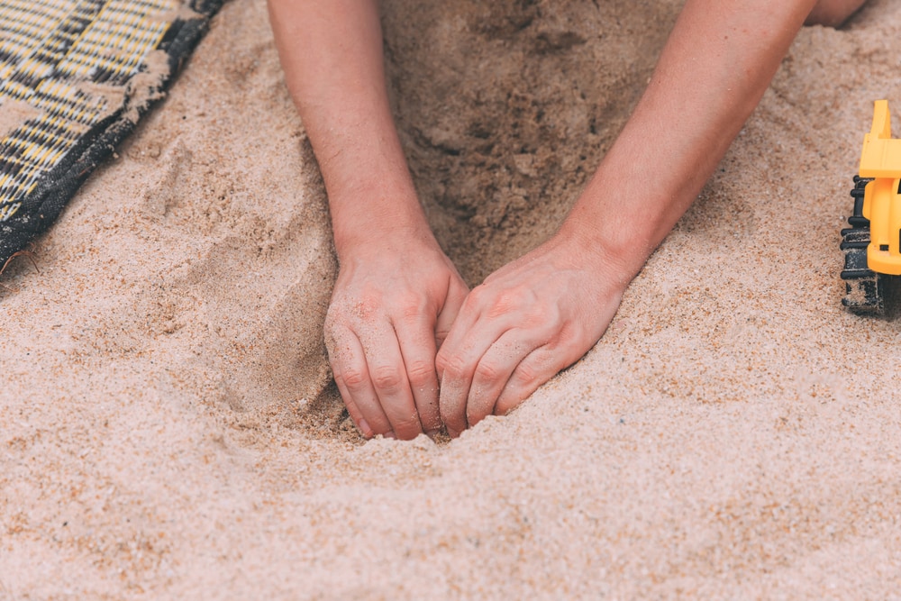 Human digging soil using bare hands