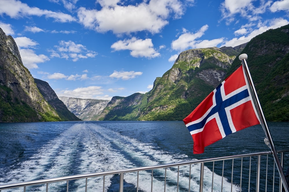 Cruise ship roaming on fjord with Norway flag