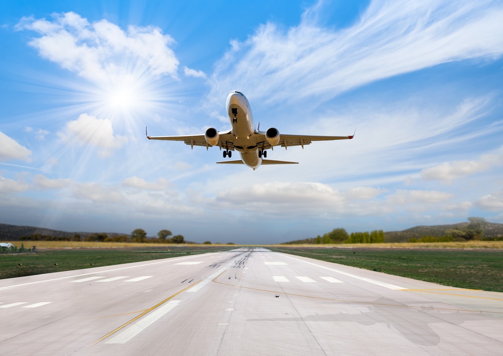 Plane taking off to the sky with clouds on its background