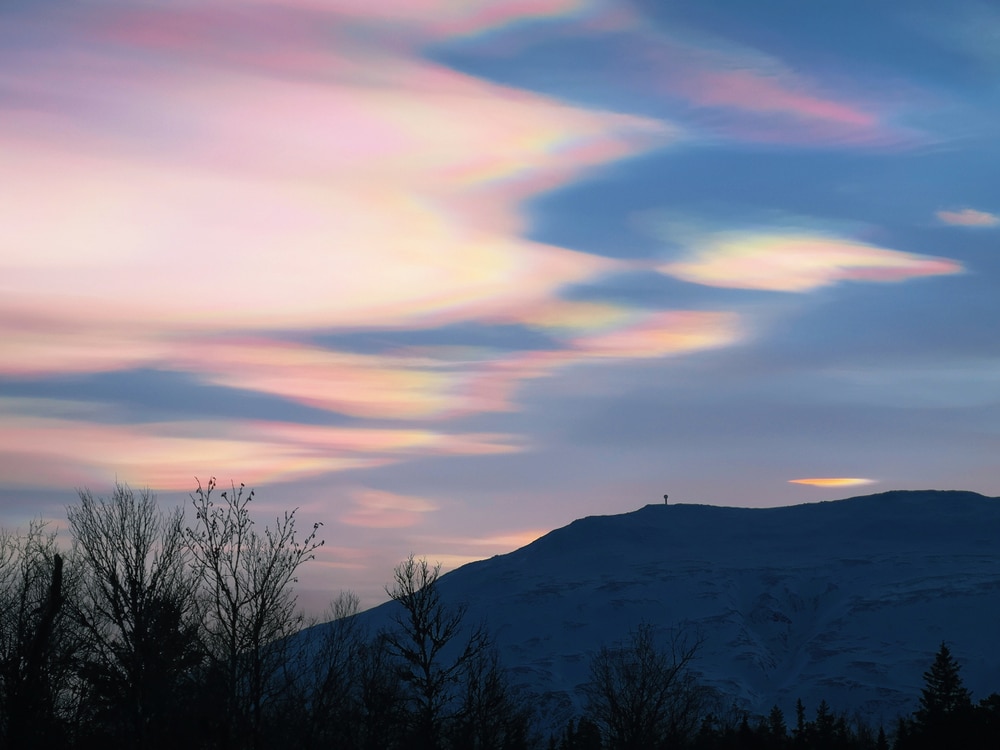 Stratosphere with rainbow clouds on top of a mountain