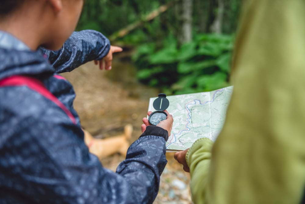 tourist reading a compass and a map