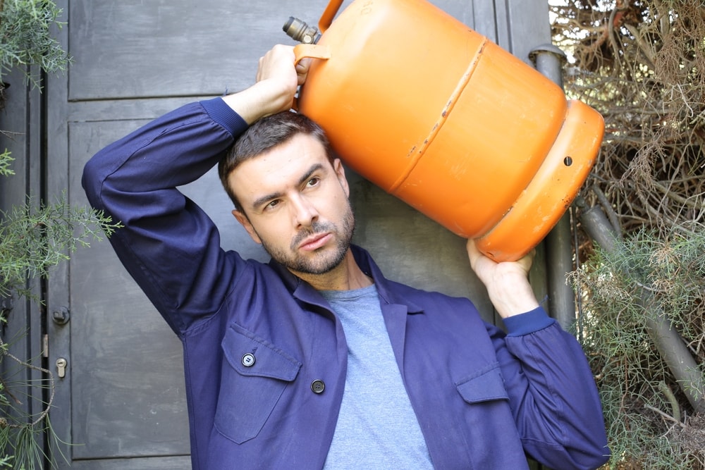 a man carrying a propane tank