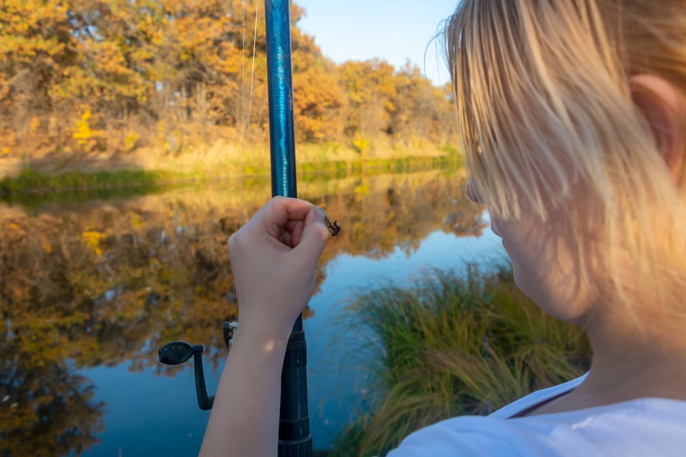 Girl holding a live worm to bait for fishing