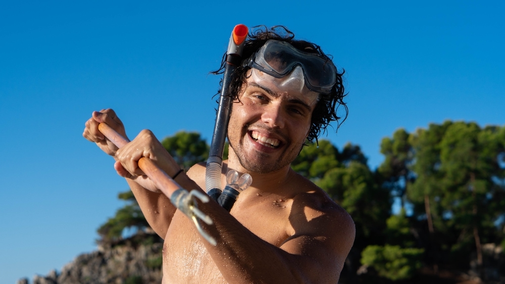 Man smiles as he does gigging fishing
