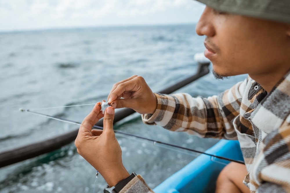 Man putting a bait on his rod