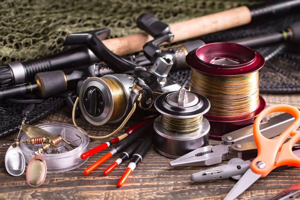 Fly fishing gears laying on a wooden table