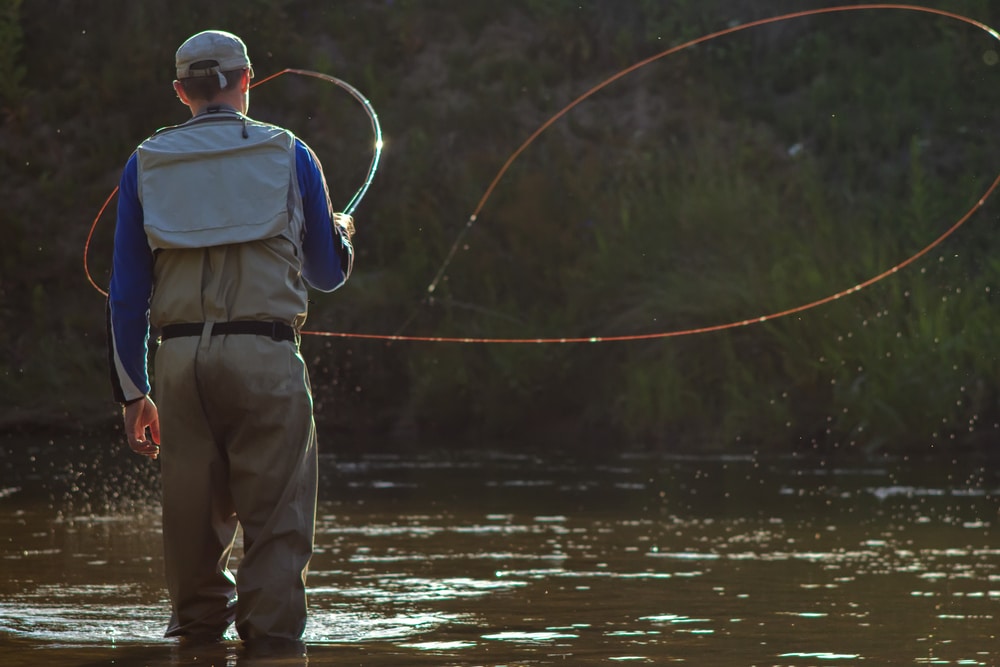 Man casting its rod towards the river