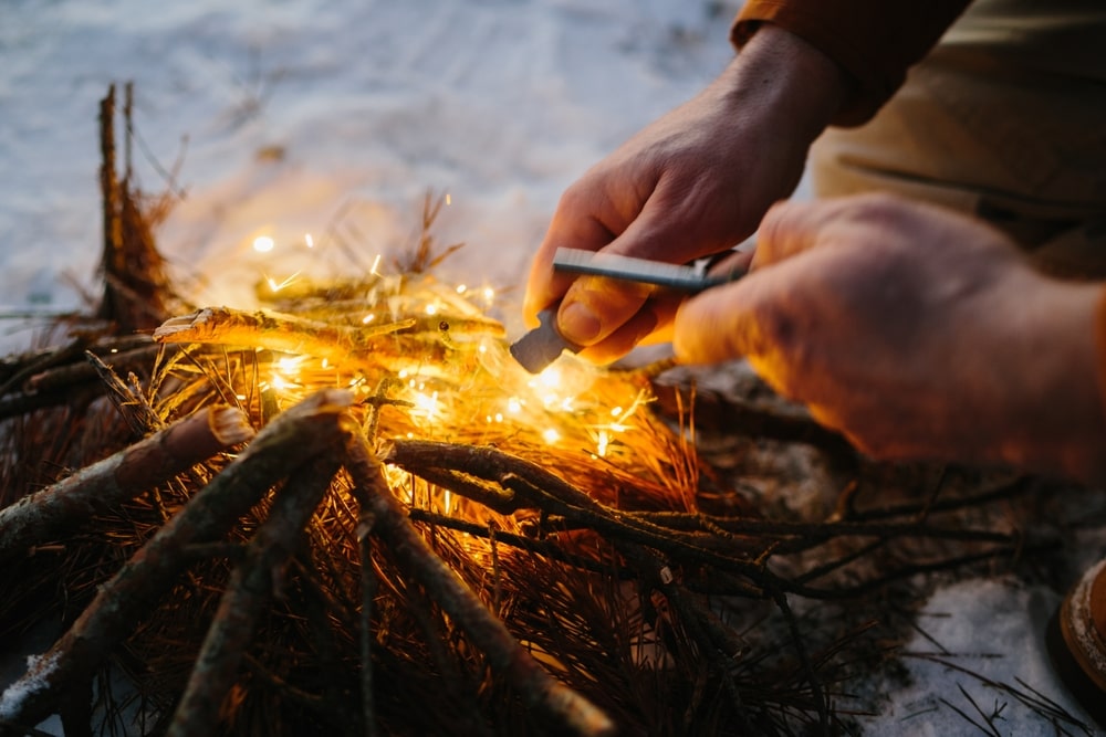 Grass being lit using magnesium ferro rod manual striker
