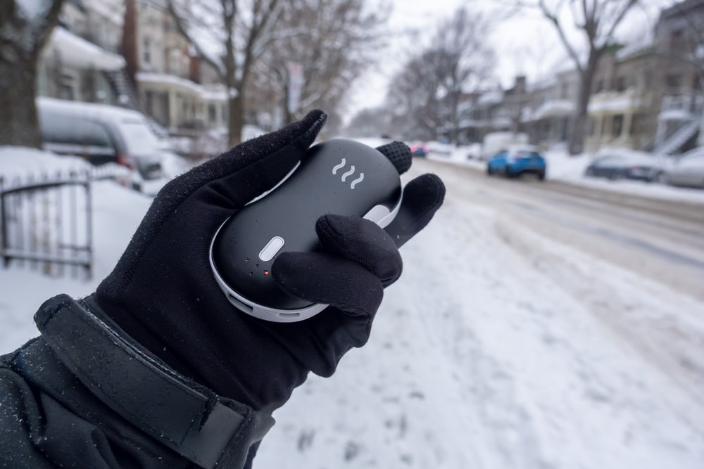a hand holding a battery operated hand warmer