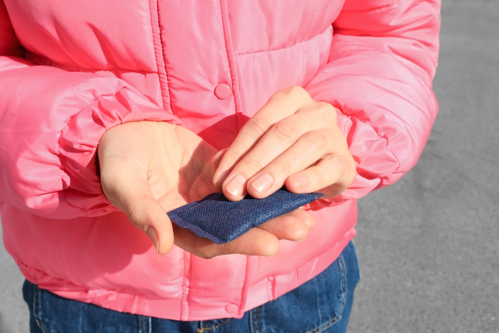 Woman holding hand warmer outdoors