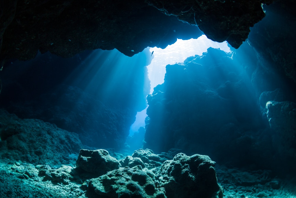 Rays of the sunlight hitting the rocks under the ocean