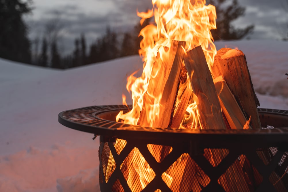 a firewood burning in a firepit in a snow