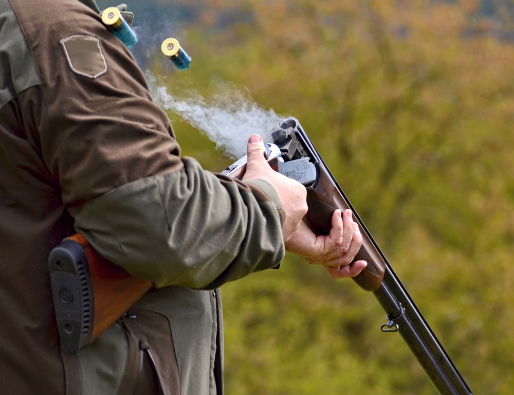 gunman with smoking shotgun after a shot