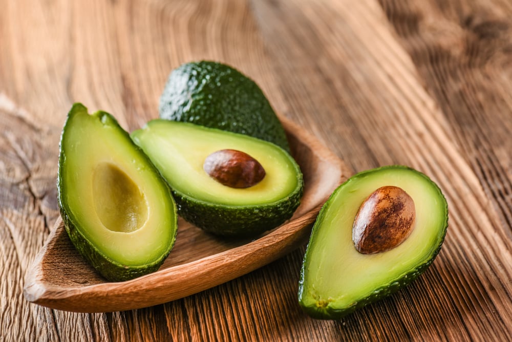 Avocadoes laying on the wood