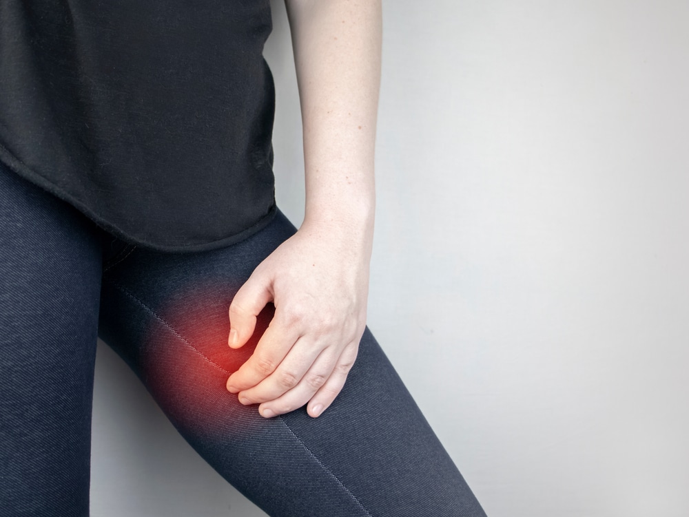 a woman holding her inner leg suggesting pain and irritation