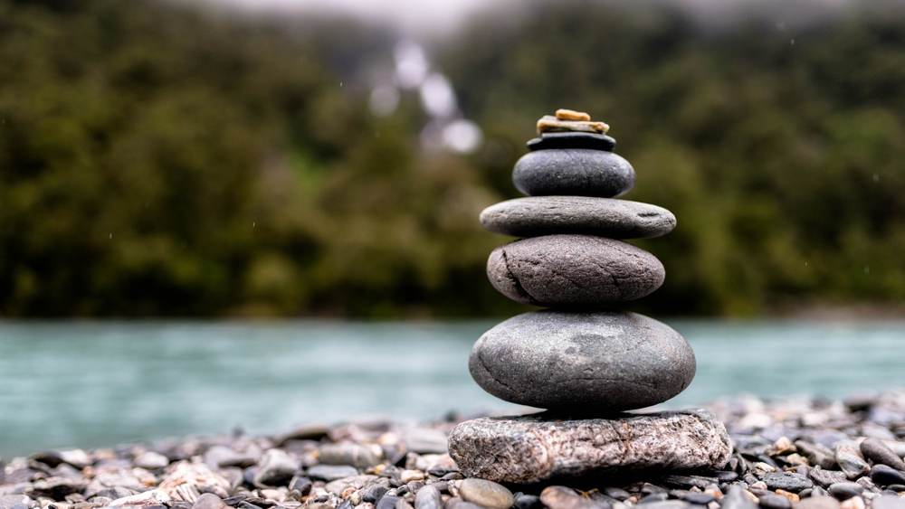 Image of stacked rocks Infront of a waterfall