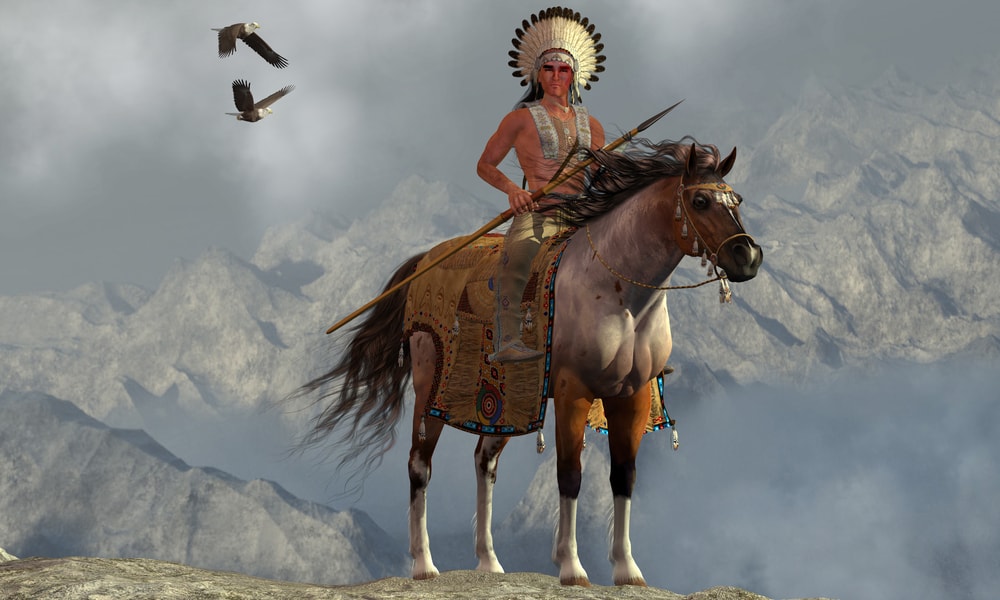 Two Bald Eagles  and an American Indian  on a tall cliff in a mountainous area